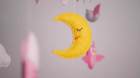 Baby Mobile with Pink Handstitched Animal and Bird Toys with Yellow Moon on White Wall Background