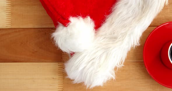 Close-up of coffee cup with saucer and santa hat