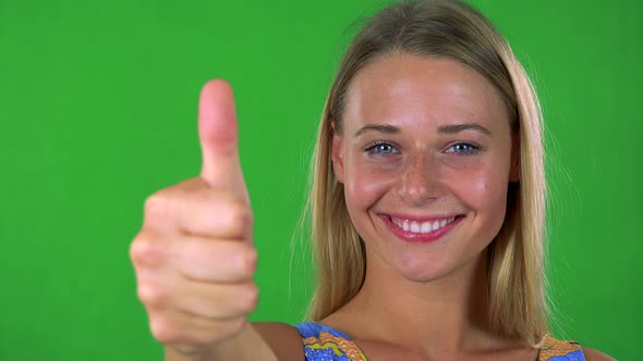 Young Pretty Blond Woman Shows Thumb Up on Agreement - Green Screen - Studio