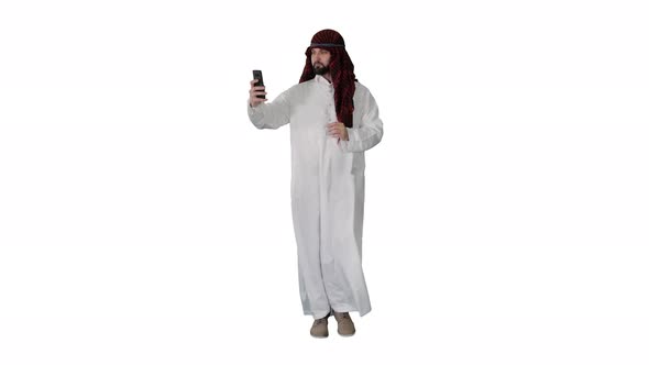 Arabian Man Walking and Making a Selfie with His Phone on White Background.