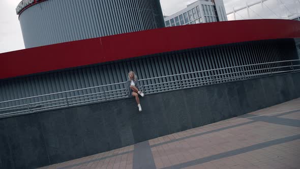 Urban Woman Sitting Building Posing for Camera on City Street