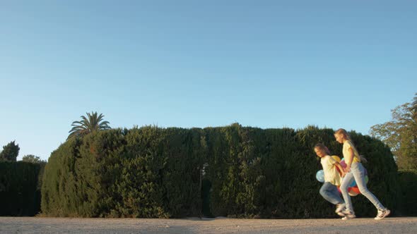 Little Girls Running in a Hedge Maze, Two Sisters Kids Hold Hands and Run in Big Green Labyrinth in