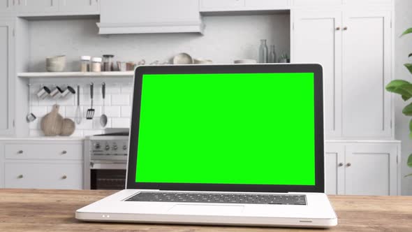 Laptop with Green Screen On Table With Kitchen Backgrounds 