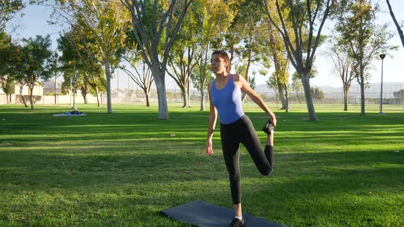 A young woman balancing and stretching before her yoga workout to stay healthy and prevent injury SL