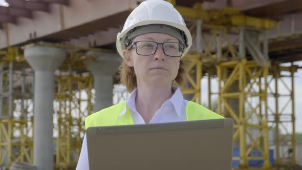 Woman in A Construction Helmet and Yellow Vest