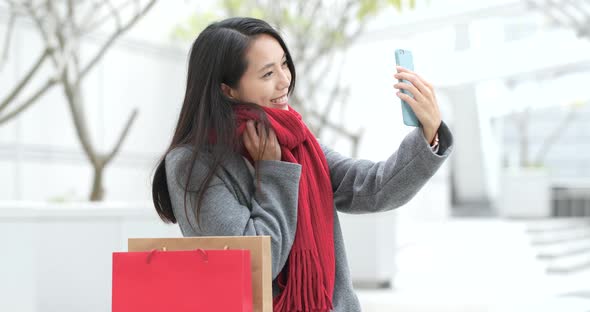 Woman use of smart phone and holding shopping bag