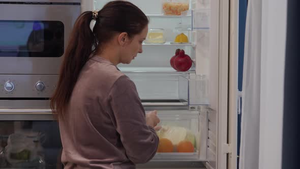 Woman Putting Food in the Fridge Clean Integrated Refrigerator Built Into Kitchen Housing