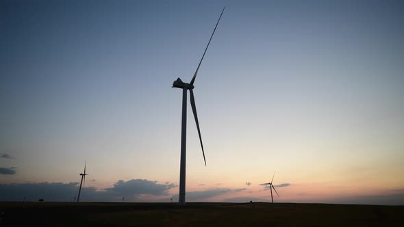 Landscape View of Windmills Farm Wind Generators for Energy Production on Sunset