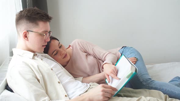 Young Man and Woman in Casula Clothes Resting in the Bedroom