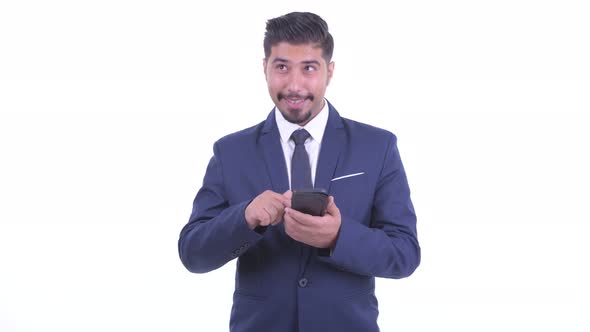 Happy Bearded Persian Businessman Thinking While Using Phone