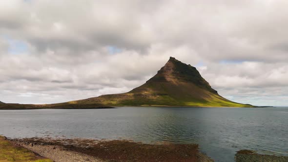 Famous Icelandic Mountain Kirkjufell with Lake and Ocean on the Background