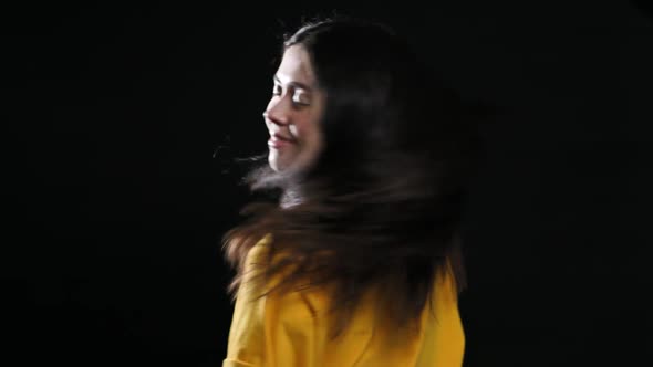 A Young Smiling Girl Shakes Her Head in Different Directions Showing Her Beautiful Dark Hair