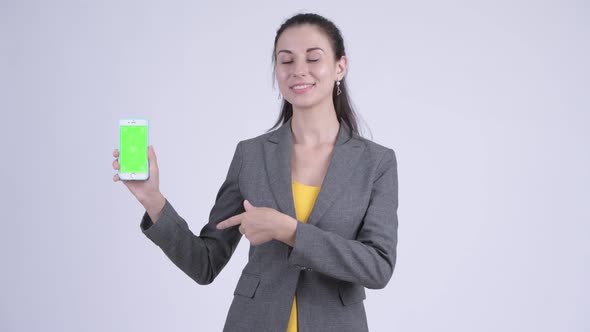 Happy Young Beautiful Businesswoman Showing Phone and Giving Thumbs Up