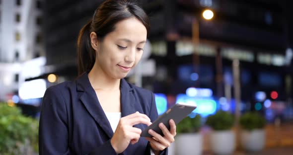 Woman Using cellphone with the background of Hong Kong city 