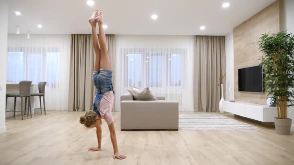 Preteen Girl Standing Upside Down on Her Arms in Living Room