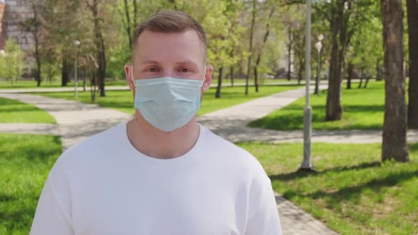 Man in Face Mask Posing for Camera Outdoors