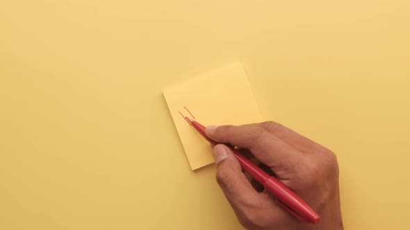 Writing Hello Text on a Sticky Notepad on Yellow Background