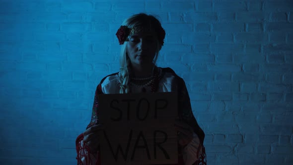 Ukrainian Woman in National Dress Holding a Sign No War Stop War