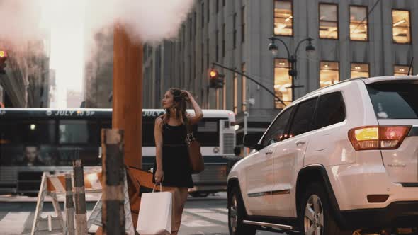 Young Beautiful Woman Standing Near the Traffic Road in Downtown of New York, America Close To Smoke