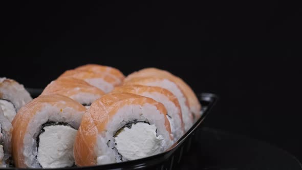 Sushi Rolls Rotating in Plastic Box