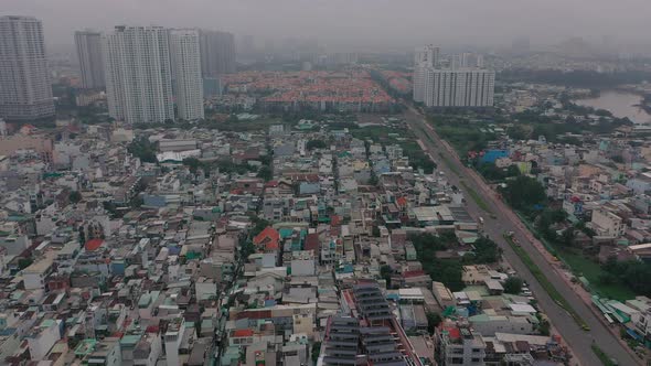 Foggy,smoggy early morning drone footage over urban high-rise and housing developments in district s