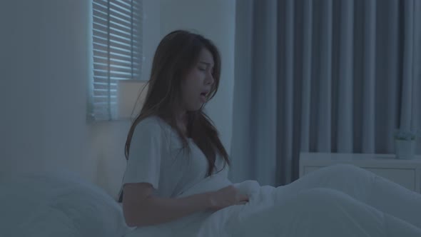 Asian beautiful sick girl in pajamas get up from sleep at dark night.