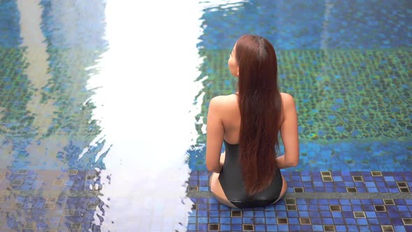 Young asian woman enjoy around outdoor swimming pool for leisure