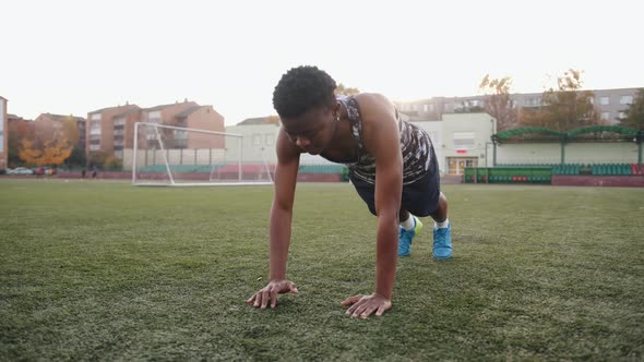 Young Black Girl Training on the Soccer Field and Standing in a Push Up Position on One Arm