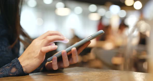 Woman use of mobile phone in coffee shop