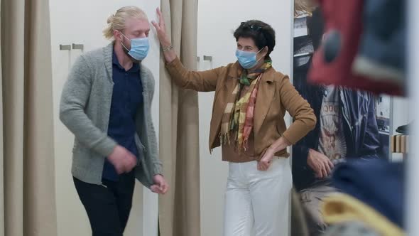 Confident Elegant Woman in Covid Face Mask Waiting for Husband in Shop Dressing Room. Smiling Wife