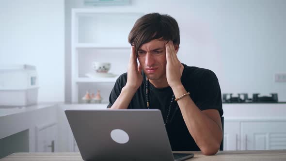 Sad Male Freelancer Suffering From Headache While Working on Laptop Worrying About Problems While