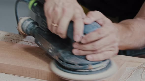 Man Worker Grinding a Wooden Pieces Using a Circular Instrument