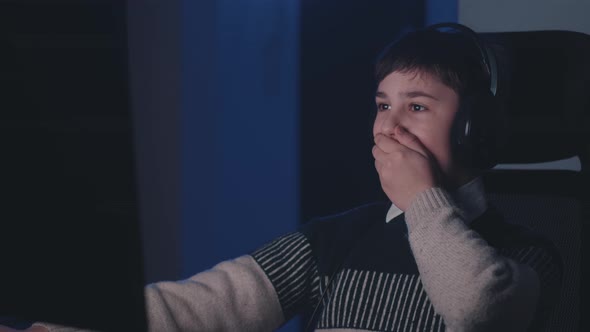 Scared Boy in Headphones Shocked By Terrible Scene While Watching Horror Video on Computer