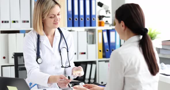 Happy Woman Listens to a Doctor with a Breast Implant