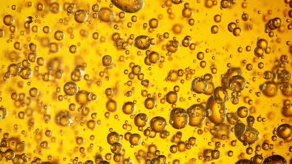 Super Slow Motion Shot of Moving Oil Bubbles on Golden Background at 1000Fps