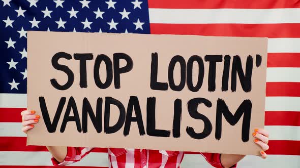 Protester Holds a Banner with a Slogan - Stop Vandalism and Looting - Against Background of the USA