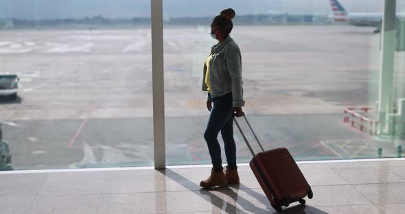 Mature african woman wearing safety face mask inside airport