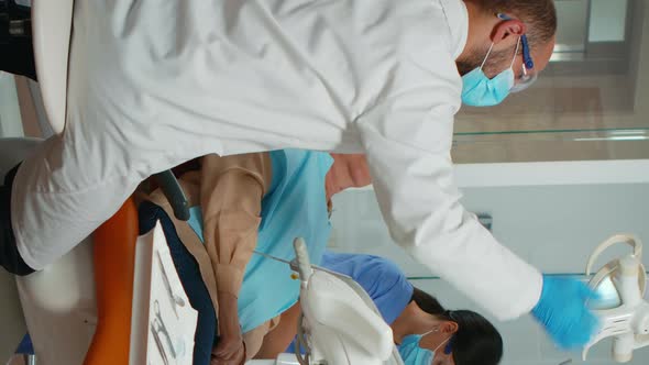 Vertical Video Dentist Treating Teeth to Senior Woman Patient in Clinic