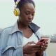 Young woman with headphones holding smart phone in city, Milan, Italy - VideoHive Item for Sale