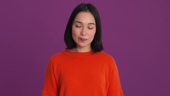 Surprised woman in red sweater clapping hands