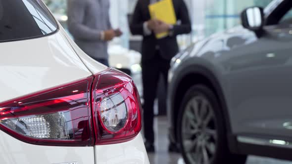 Selective Focus on a Car, Salesman Talking To the Customer on the Background