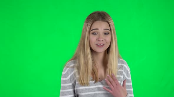 Portrait of Cute Blonde Girl with Long Hair with Shocked Wow Face Expression on a Green Screen