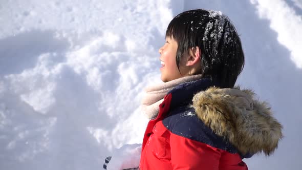 Cute Asian Child Wearing Winter Clothes Playing On Snow In The Park