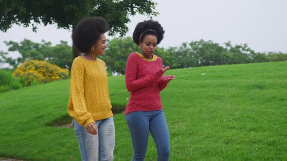 Two mixed race women walking in park