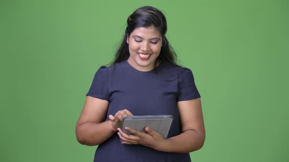 Young Overweight Beautiful Indian Businesswoman Against Green Background