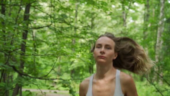 Young Female Athlete Running Through the Woods