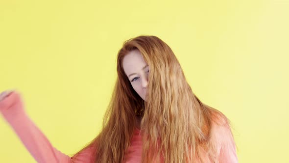 woman on yellow background dances and enjoys life.