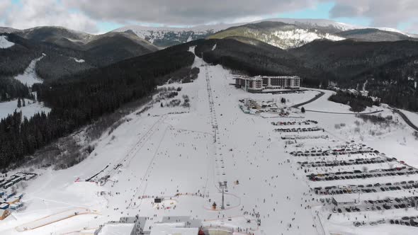 Aerial Ski Slopes with Skiers and Ski Lifts on Ski Resort in Snowy Mountains