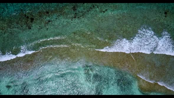 Aerial drone shot panorama of tranquil island beach trip by blue water with white sandy background o