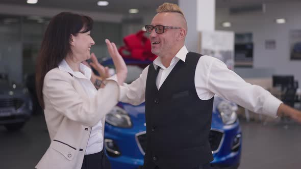 Excited Adult Couple Rejoicing Car Winning in Dealership in Slow Motion